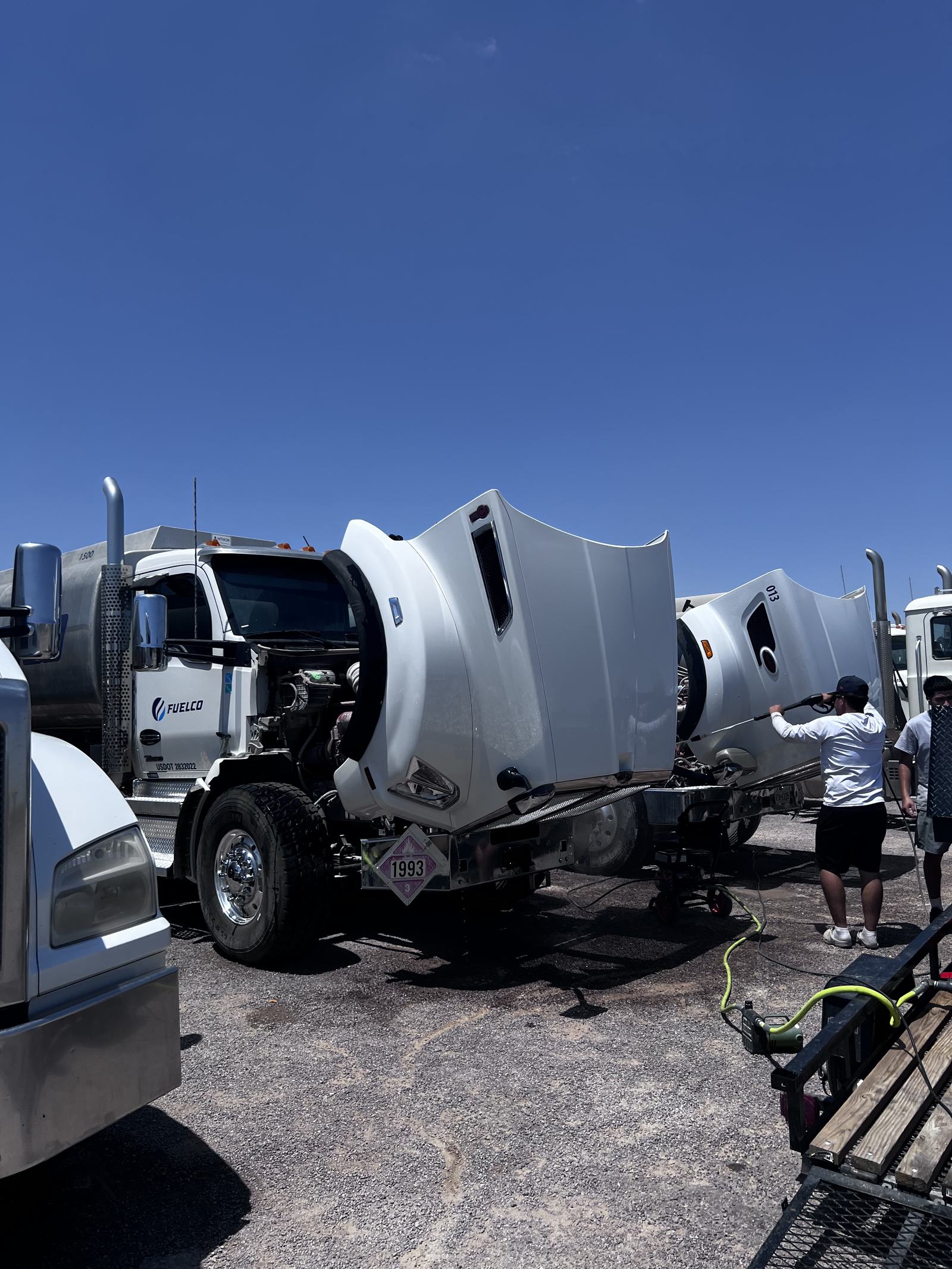 Black Label crew washing raised hoods on tanker trucks